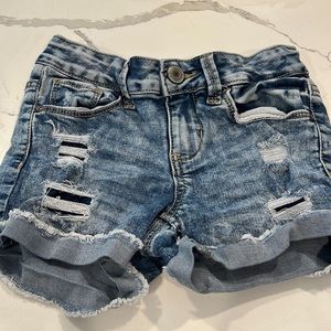 Girls stonewashed ripped jean shorts.